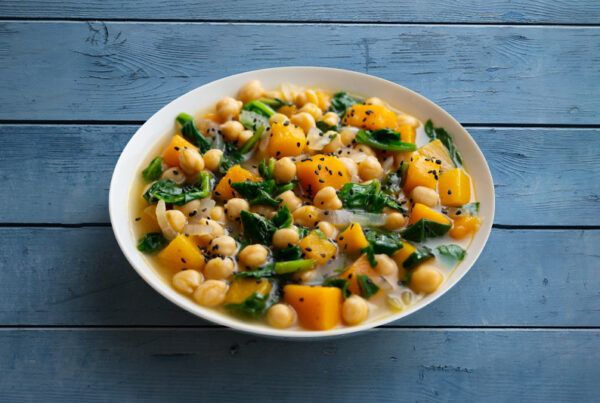 Cebolla dulce - Plato de garbanzos con espinacas y calabaza sobre una mesa de madera color azul