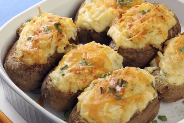 Fuente de horno blanca con receta de patatas rellenas de cebolla dulce caramelizada y paté