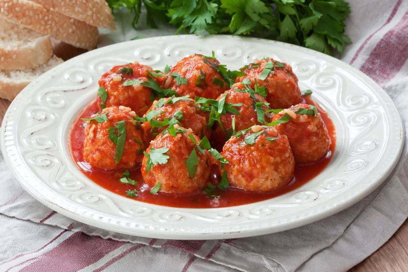Plato blanco con albóndigas realizadas con garbanzos y cebolla dulce para vegetarianos sobre una servilleta a cuadros